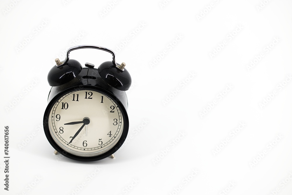 A black alarm clock with two bells on top, chrome handle, and legs, set against a white background. Timeless design meets functionality in this sleek, monochromatic timepiece.. A black alarm clock with two bells on top, chrome handle, and legs, set against a white background. Timeless design meets functionality in this sleek, monochromatic timepiece..