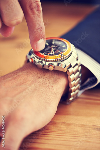 Hands, table and wristwatch with pointing time for deadline at office, table and schedule for business. Closeup, check and appointment for work with commitment, punctual and plan for meeting photo