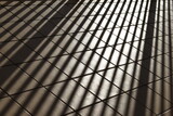 Sunlight illuminating tiled floor creating grid shadows