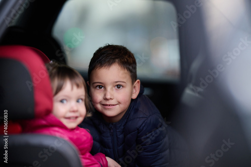 A young brother and sister enjoying a car ride together, immersed in the adventure of travel
