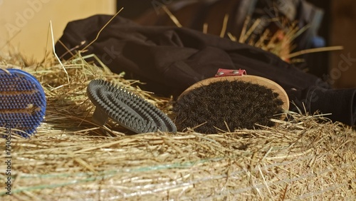 Horse Grooming Kit Body Brush and Flexible Large Rubber Curry Comb Left on Hay Roll in Stables
