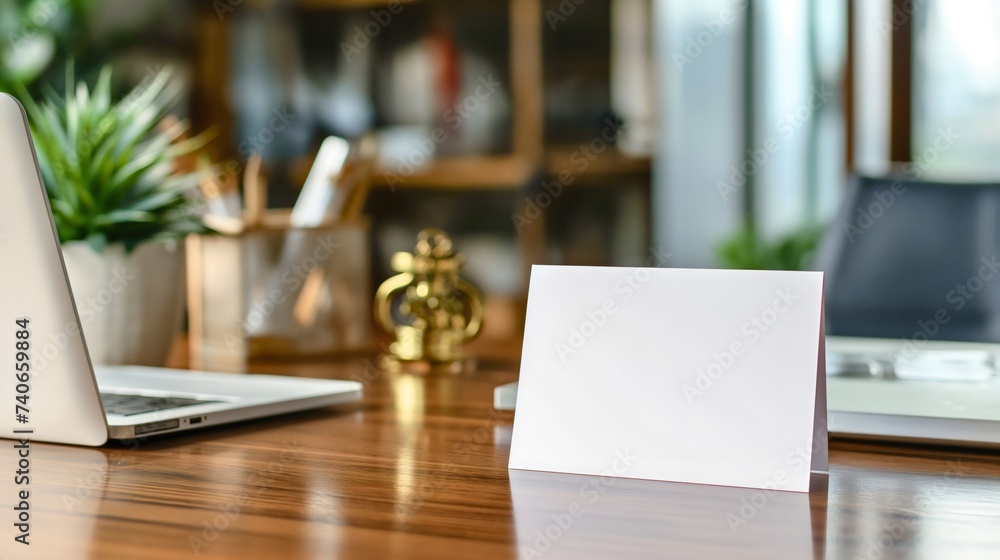 Empty white blank business card on a wooden office table or desk closeup, next to the laptop or notebook device. Stack mockup for brand or company logo printing