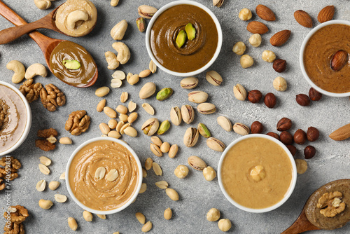 Tasty nut butters and raw nuts on light grey table, flat lay © New Africa