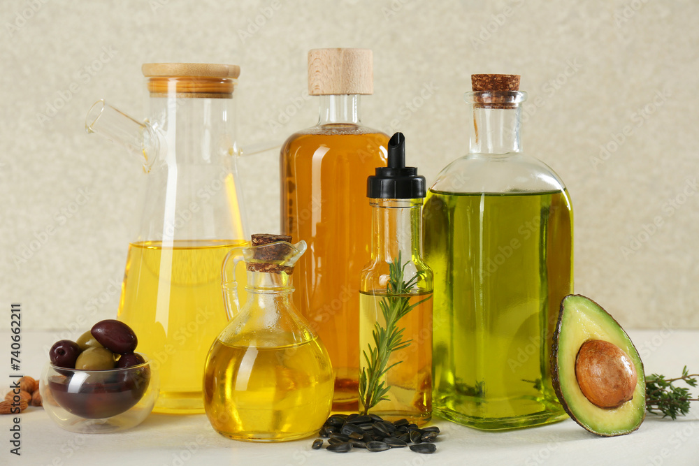 Vegetable fats. Different cooking oils in glass bottles and ingredients on white table Vegetable fats. Different cooking oils in glass bottles and ingredients on white table