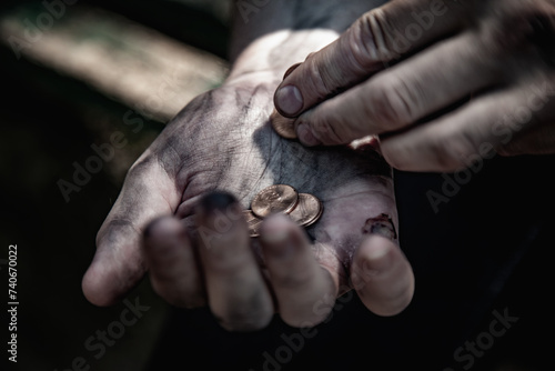Conceptual photo: poverty, hunger, injustice and social inequality. A man counts coins to buy food.