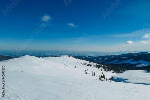 Snow covered meadow with panoramic view of hills and mountains seen from Kor Alps  Lavanttal Alps  Carinthia Styria  Austria. Winter wonderland in Austrian Alps. Ski touring on untouched landscape