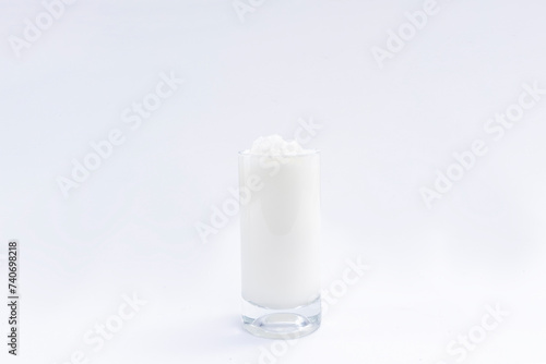 A glass of foamy ayran isolated on white background. Ayran is a traditional Turkish fermented milk drink. photo