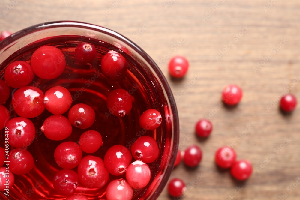 Tasty cranberry juice in glass and fresh berries on wooden table, top view. Space for text Tasty cranberry juice in glass and fresh berries on wooden table, top view. Space for text