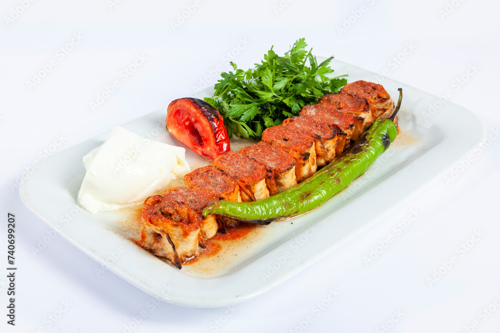 Close up view of traditional grilled beyti kebab rolls with pita bread, yogurt, pepper, tomato and fresh parsley isolated on white background. Close up view of traditional grilled beyti kebab rolls with pita bread, yogurt, pepper, tomato and fresh parsley isolated on white background.