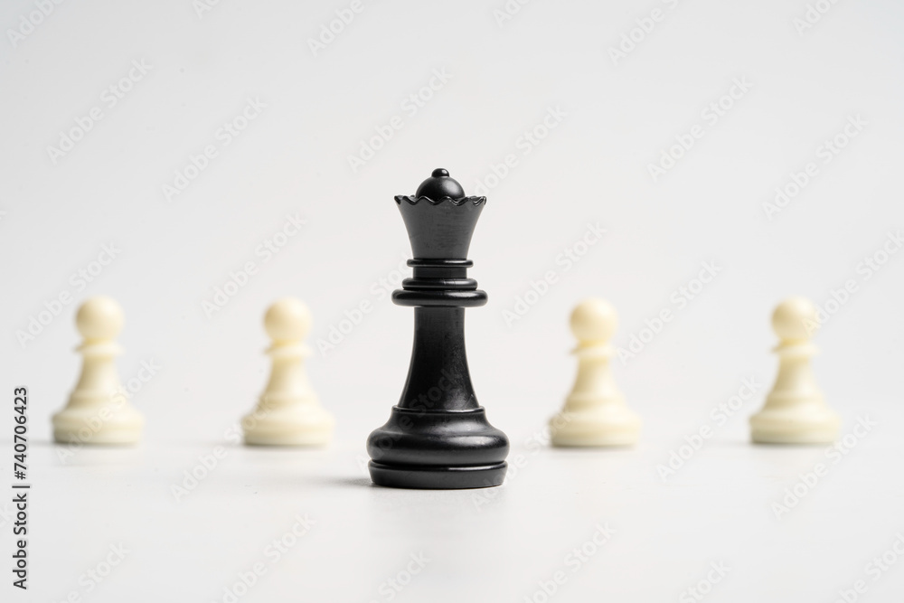 Black queen chess standing in front of white pawn chess for leadership concept.
