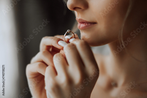 Close-up of an elegant diamond ring on a woman's finger with a modern manicure, sunlight. Love and wedding concept. Soft and selective focus.
