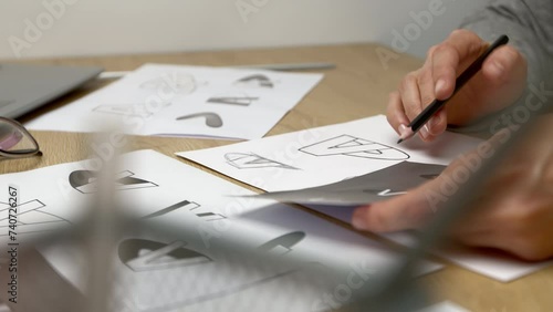 Logo design and creation. The designer draws a sketch of the brand on paper.