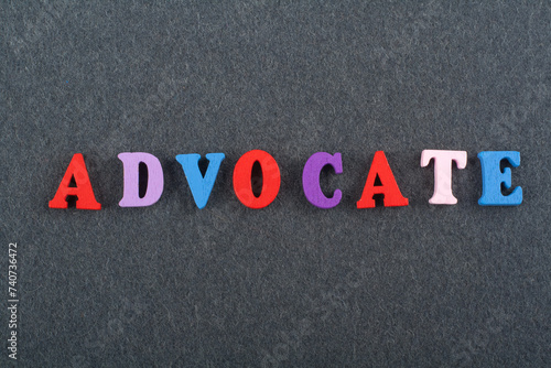 ADVOCATE word on black board background composed from colorful abc alphabet block wooden letters, copy space for ad text. Learning english concept.