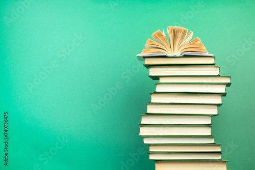 Open book, hardback books on wooden table, on a green background. Back to school. Copy space for text. Education background.