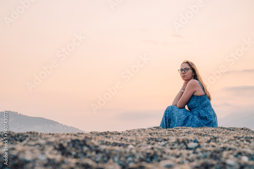 Woman sits on the beach and...