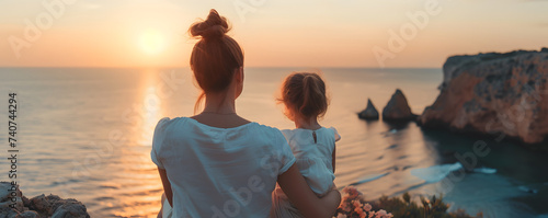 Back view of a mother and her daughter at sunset. Concept of mother day, motherhood, parent love.