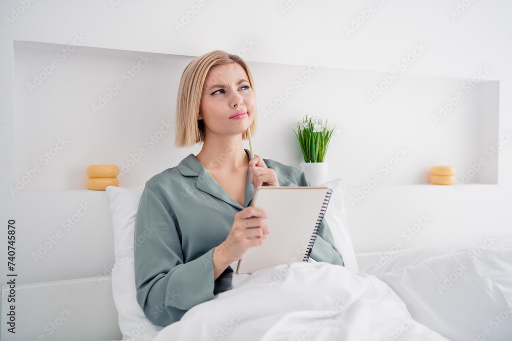 Photo portrait of lovely blonde young lady sit bed to do list notepad minded dressed stylish gray sleepwear comfortable bedroom daytime Photo portrait of lovely blonde young lady sit bed to do list notepad minded dressed stylish gray sleepwear comfortable bedroom daytime