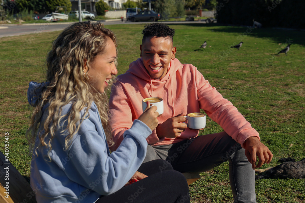 Obraz premium Young couple drinking coffee in the park.