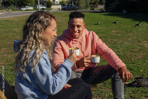 Young couple drinking coffee in the park.