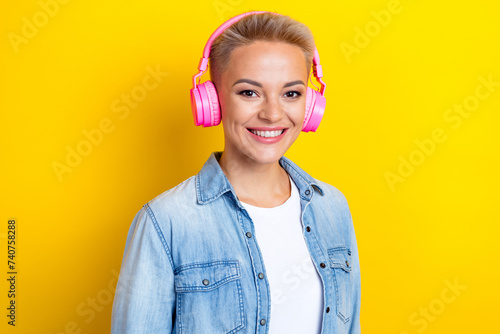 Photo portrait of attractive young woman headphones listen music dressed stylish denim clothes isolated on yellow color background photo