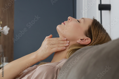 Caucasian woman touching her throat. Sore throat, cold, flu, tonsillitis or thyroid gland problem	