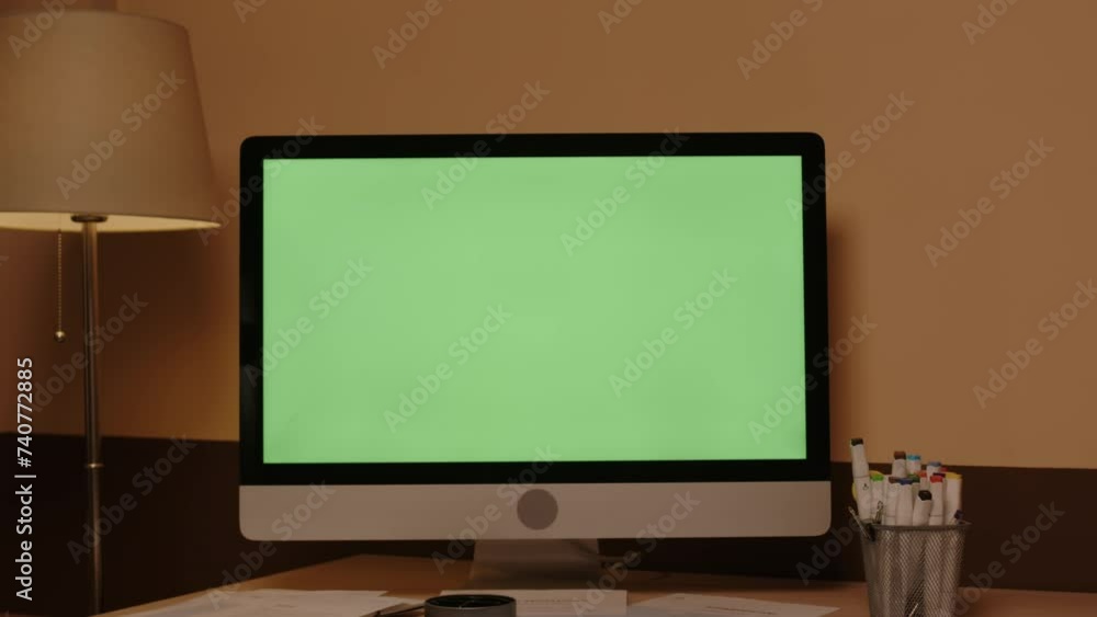 Dolly-out no people shot of computer desktop with green chroma key screen on wooden work desk at home office Dolly-out no people shot of computer desktop with green chroma key screen on wooden work desk at home office