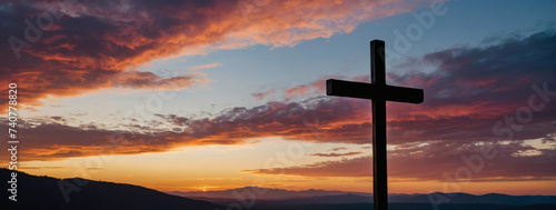 Christian symbolism at dusk - The Cross of Jesus against a vibrant and serene sunset background.