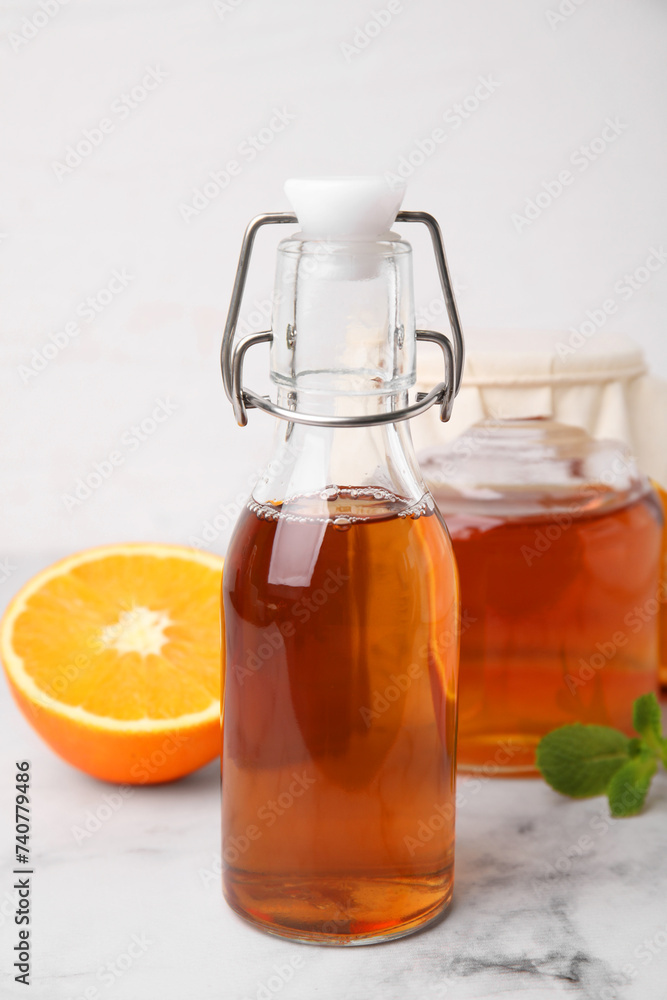 Tasty kombucha, orange and mint on white marble table Tasty kombucha, orange and mint on white marble table