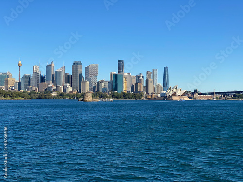 View of Sydney and its iconic buildings and skyscrapers at the distance. Australian city on the horizon. City skyline from the ocean shore. City harbour country, Australia.