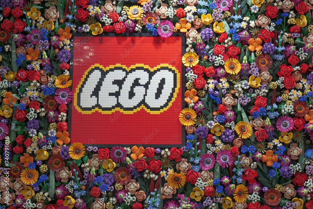 Naklejka premium A display of Lego flowers at their retail store in London, with the company logo in the center which is also made of bricks.