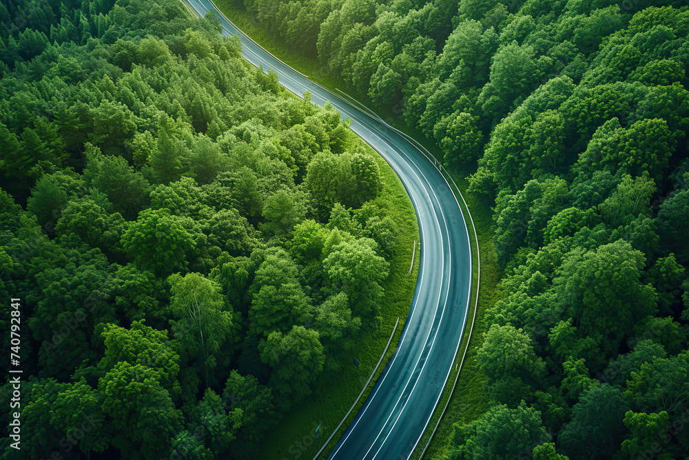 drone view of a highway through a green forest. road going through green forest adventure