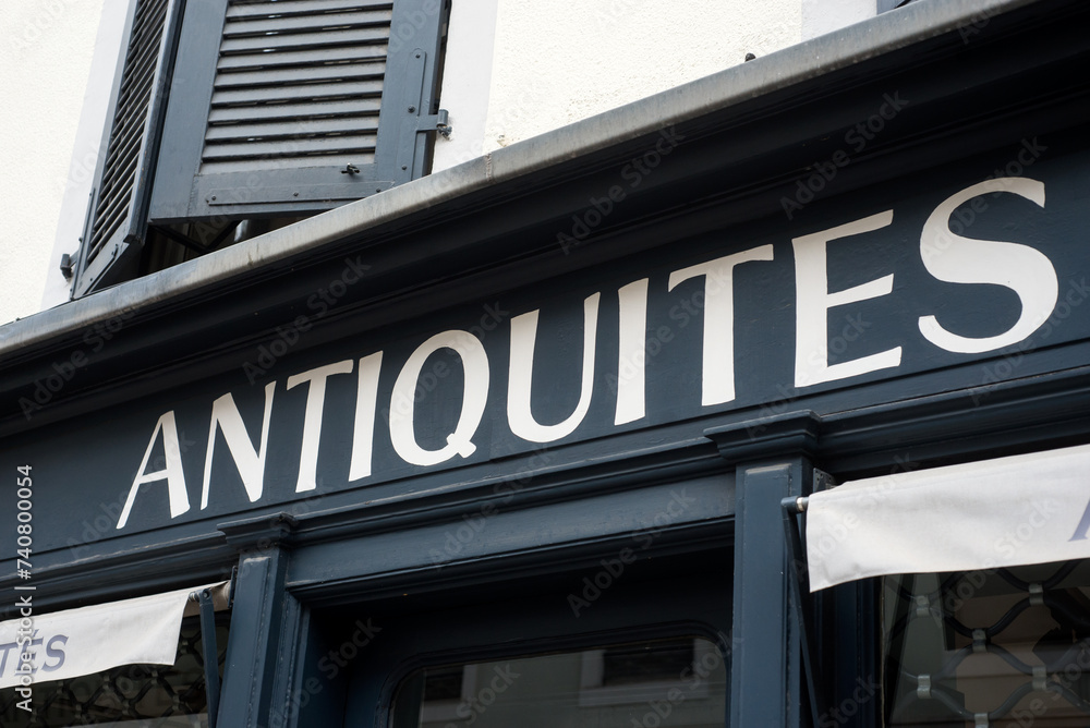 Closeup of antiques signage on store front in the street, traduction in english of antiquités in french