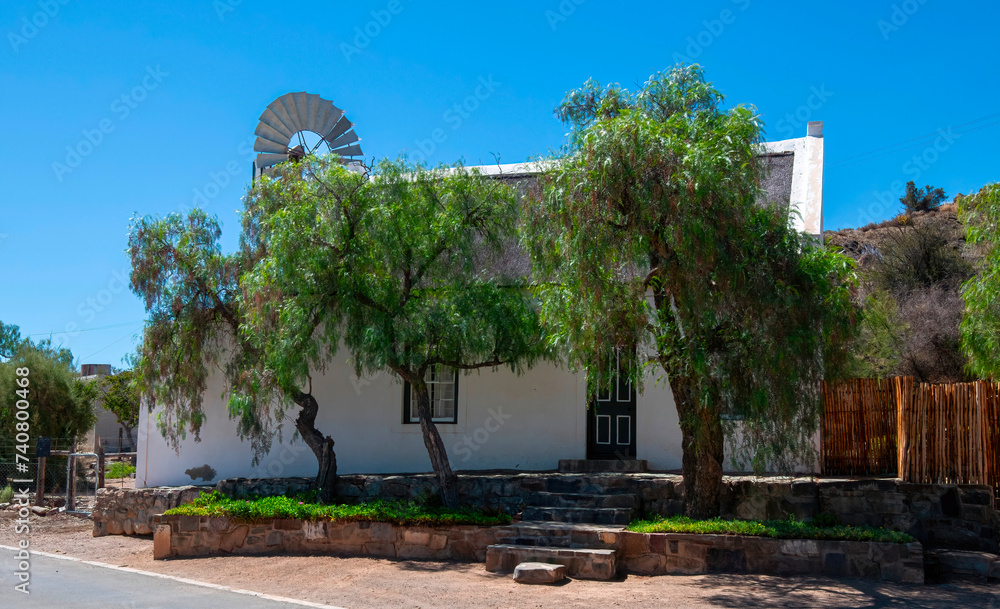 A Victorian cottage sits in the shade of pepper trees in the small village of Klaarstroom situated at the northern entrance to Meiringspoort, Western Cape 