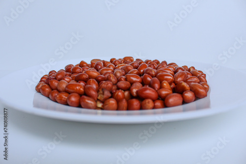 Fried groundnut, Goober or Monkey Nut, or Arachis hypogaea. On a white plate, isolated on white background photo