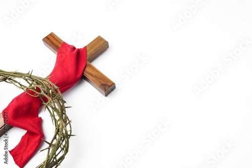 Jesus Wooden cross wrapped with red cloth and Crown of Thorns used by Catholic Christians on Good Friday Ceremony. Isolated on white background with empty blank copy text space. photo