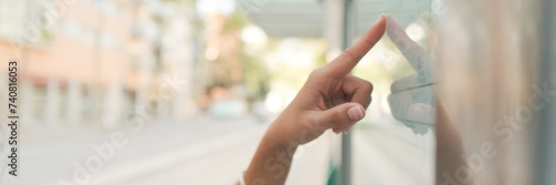 Close-up of unrecognizable woman's hand swipe finger on public transport schedule, Panorama