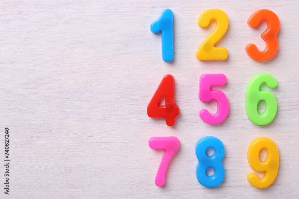 Colorful numbers on white wooden school desk, flat lay. Space for text Colorful numbers on white wooden school desk, flat lay. Space for text