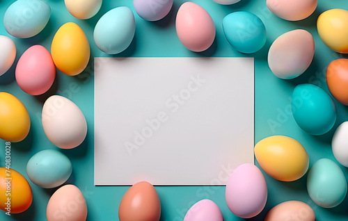 Easter flat lay banner with blank white paper and colorful easter eggs around it against blue background. Can be used as background. Trendy design. Easter Mockup.