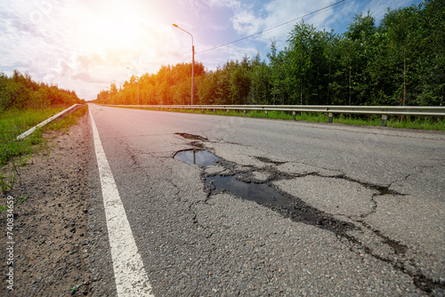 Potholes on bad asphalt road. Closeup