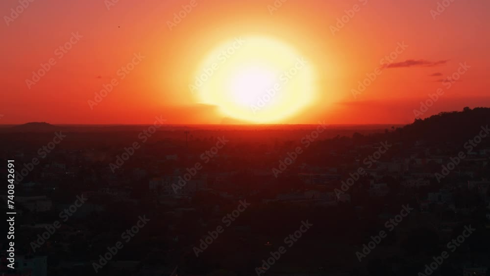 An aerial view of a cityscape bathed in magical sunset light. Sunrise over American housing with fields and hills in the background. Panorama of the city. Sunset time. Bird's-eye. Red sun. An aerial view of a cityscape bathed in magical sunset light. Sunrise over American housing with fields and hills in the background. Panorama of the city. Sunset time. Bird's-eye. Red sun.