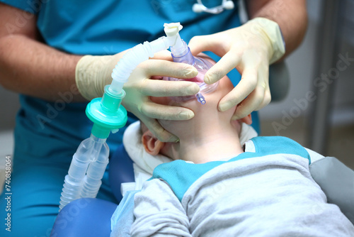 A small child is undergoing surgery. Oxygen mask on the child's face. Anesthesia during surgery. Surgical intervention. The use of sedatives.