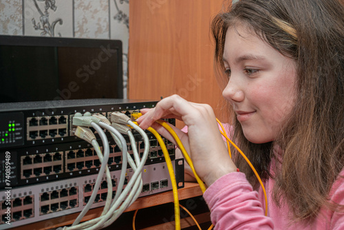 A child connects wires to a network switch. A girl sets up an Internet connection.