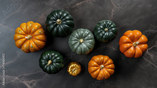 A group of pumpkins on a dark green color marble