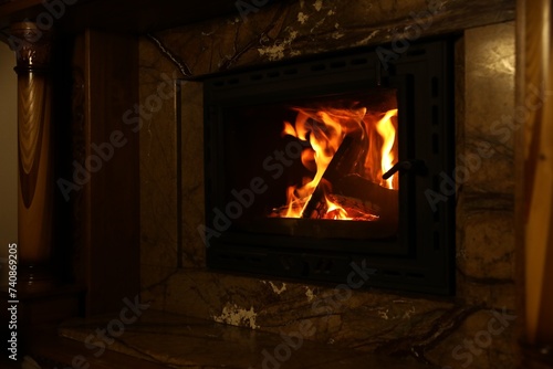 Fireplace with burning wood in darkness at home