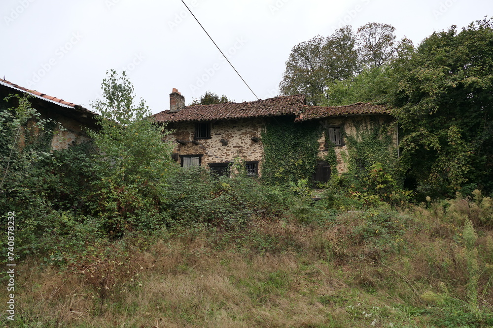 An overgrown old house nestled in a French rural area, its weathered façade and surrounding vegetation telling tales of time gone by. An overgrown old house nestled in a French rural area, its weathered façade and surrounding vegetation telling tales of time gone by.