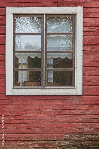 White framed window on old red painted wood wall.