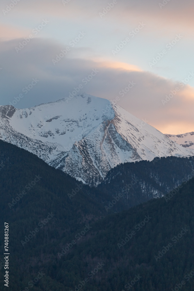 Snowy mountain peak and cloudy sky in February. Nature background, global warming, care for the planet. Pirin mountain is the highest mountain in Bulgaria with Musala peak 2925m.