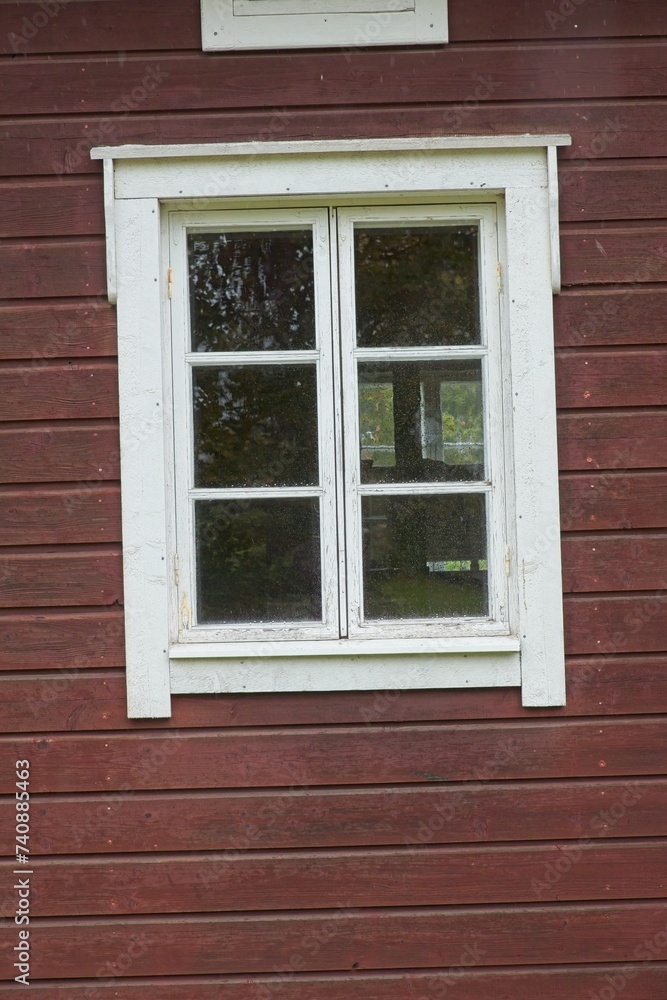 White framed window on old red painted wood wall.