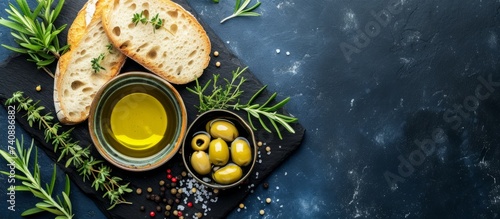 Freshly baked bread accompanied by succulent olives and drizzled with premium olive oil on a rustic slate board