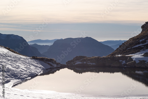 View of a pyrenean lake and mountain layers on the background at sunset. photo